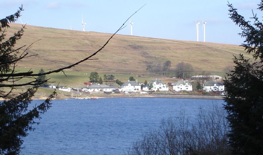 Windfarm above houses and dam at Carron Valley Reservoir