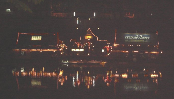 Floating restaurant illuminated at night on Nan River in Phitsanulok in Northern Thailand